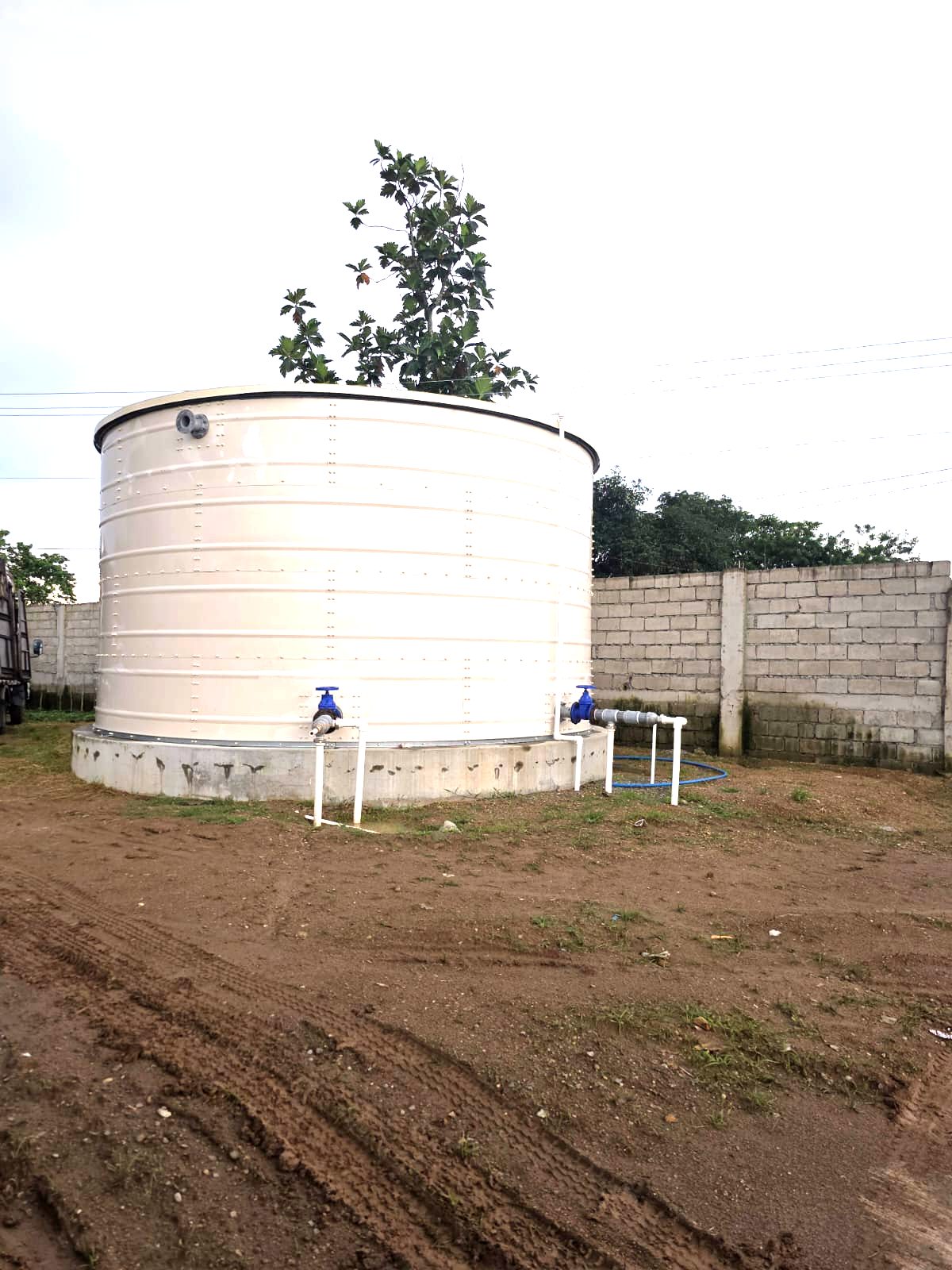 Water tank with connection pipework